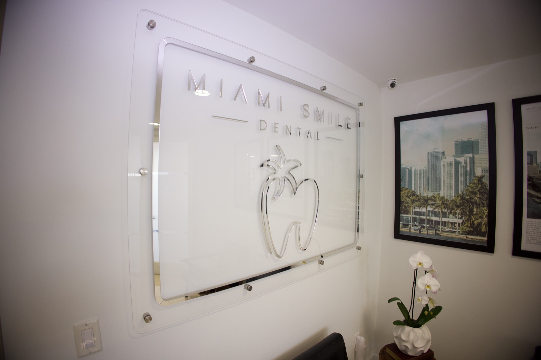 La réception et le mur de marque Miami Smile Dental à Pinecrest