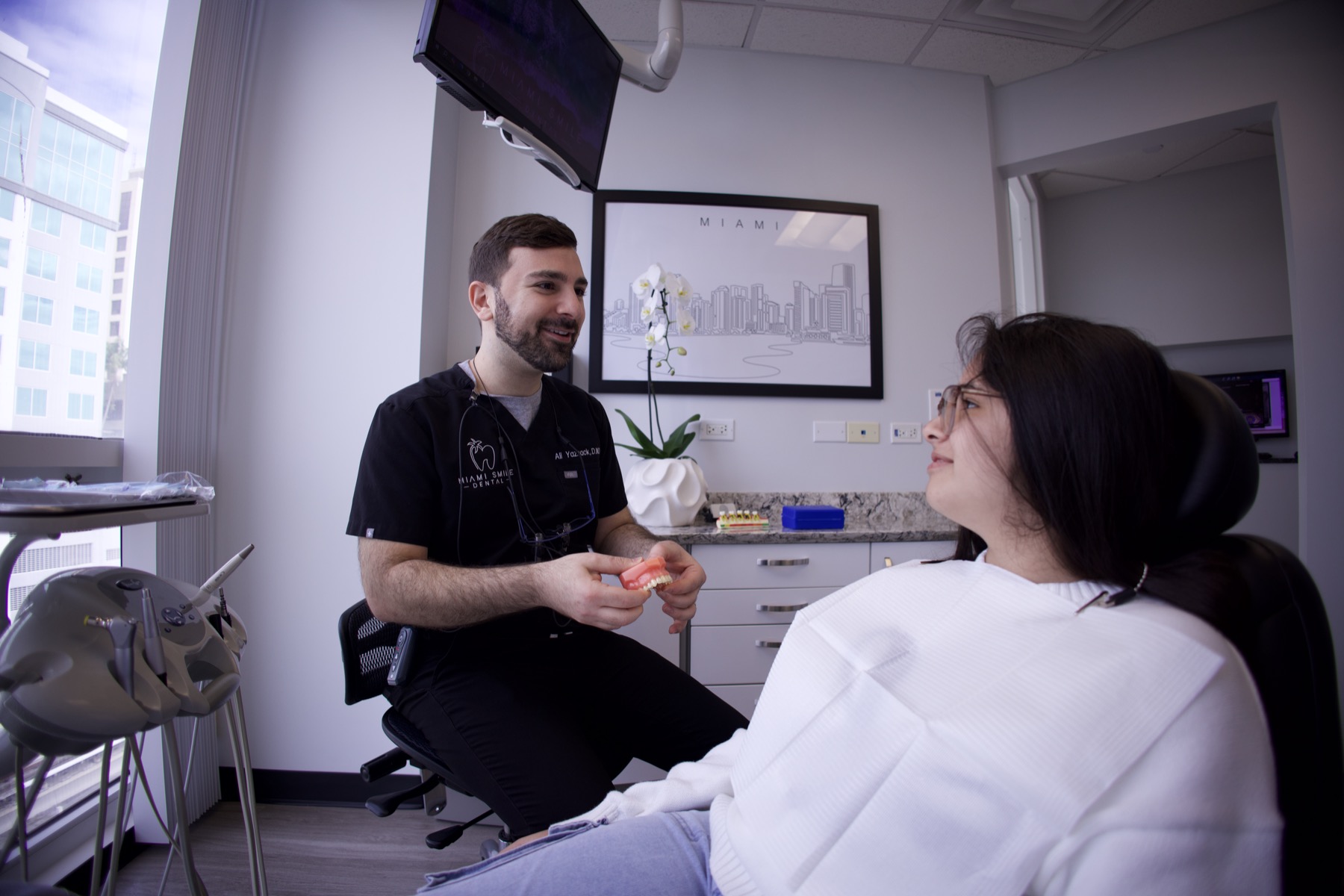 Dr. Ali Yazback talking through a treatment plan with a patient at Miami Smile Dental