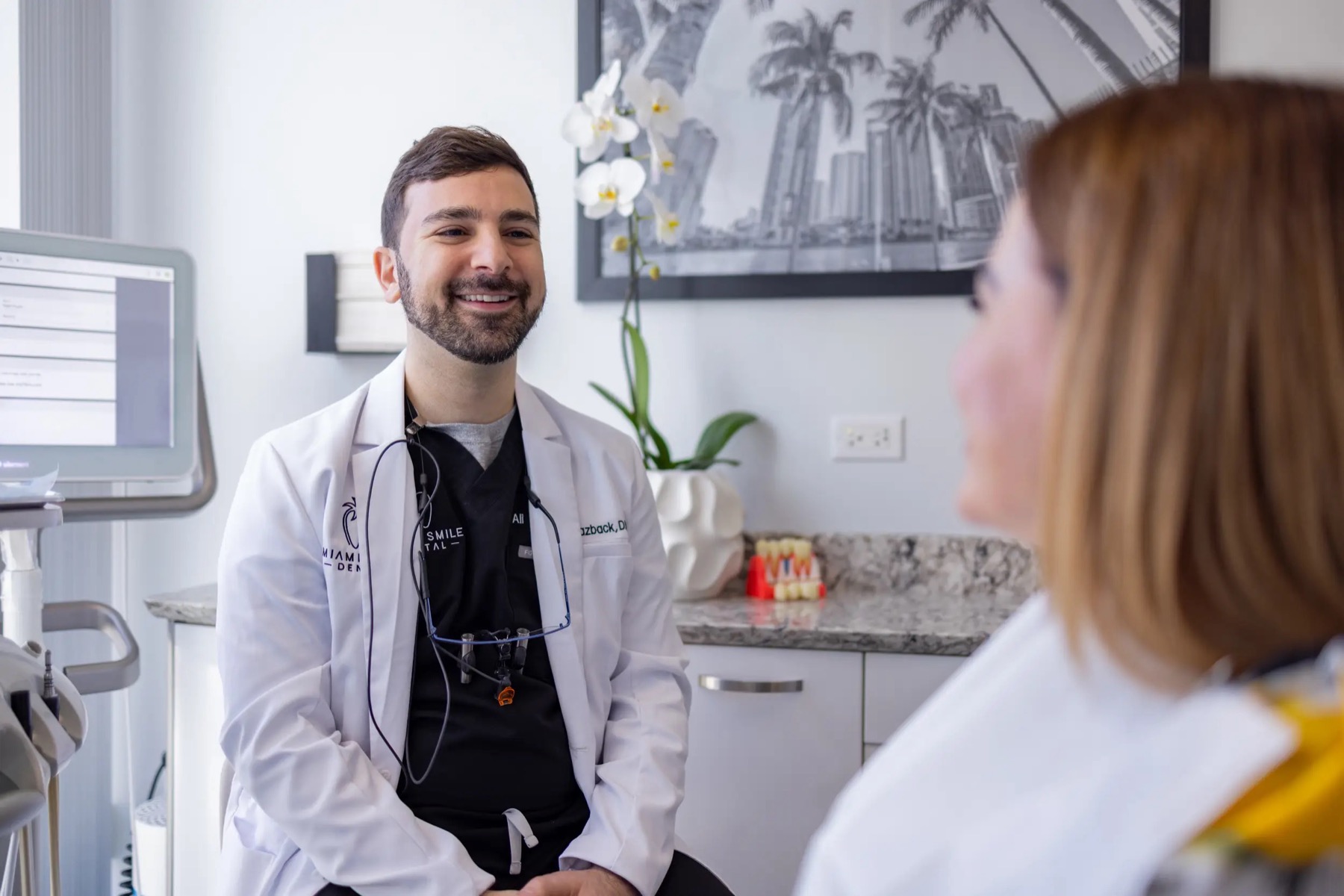 Dr. Ali Yazback talking with a patient at Miami Smile Dental