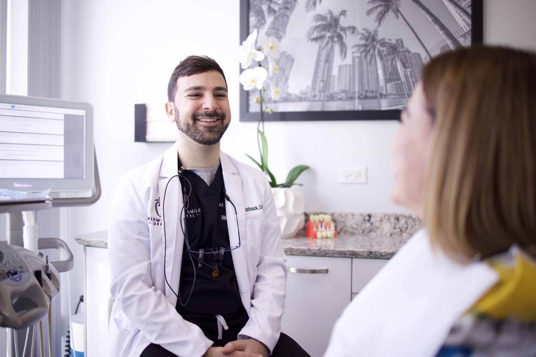 Dr. Ali Yazback talking with a patient at Miami Smile Dental in Pinecrest