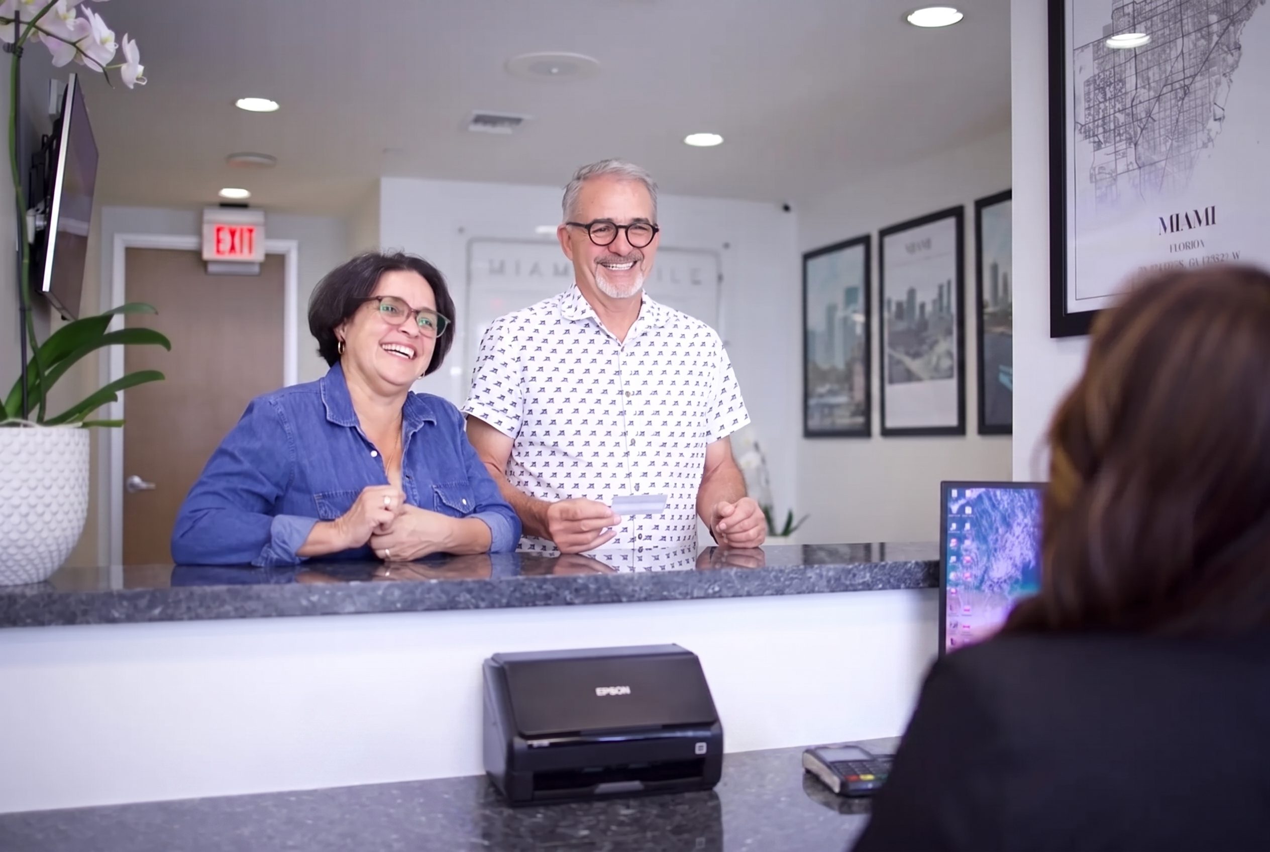 Patients welcomed at the front desk of Miami Smile Dental in Pinecrest