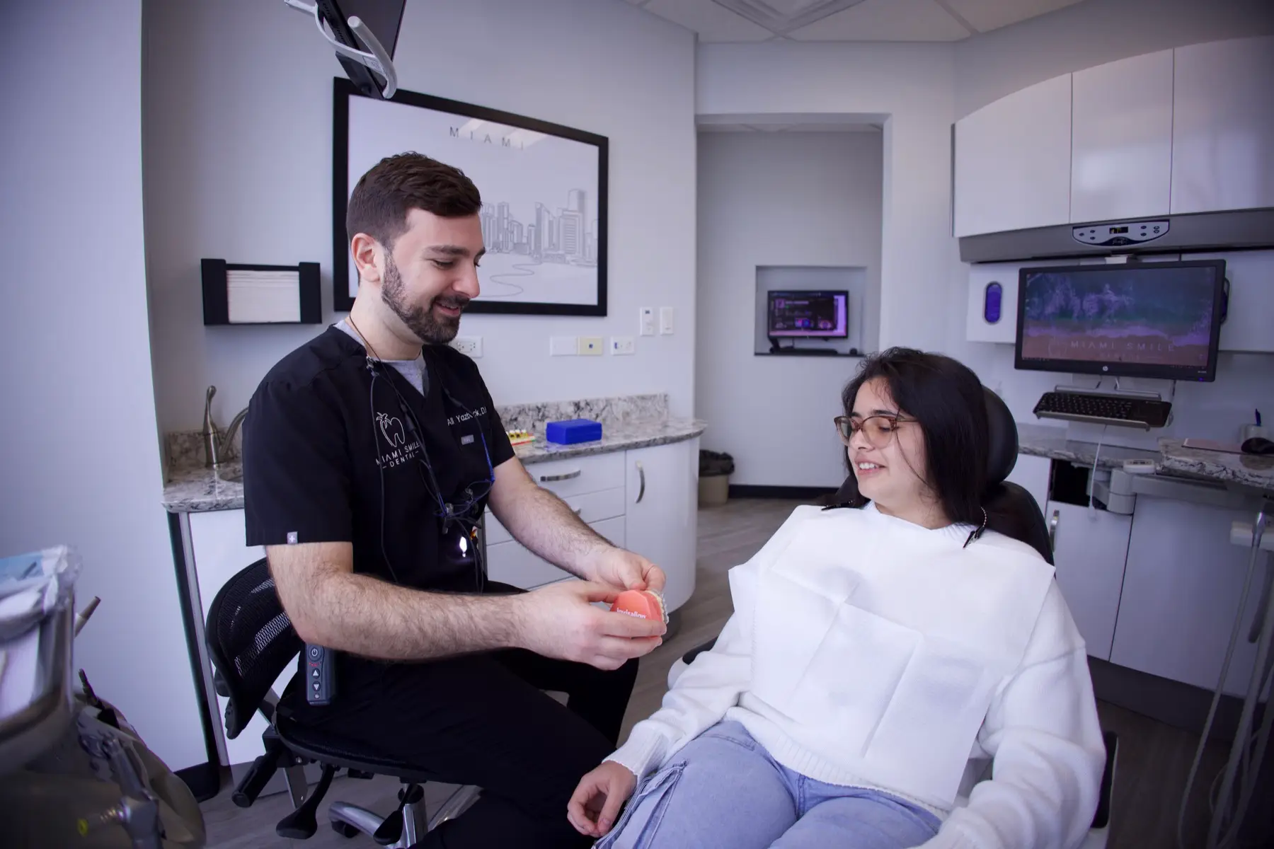 El Dr. Ali Yazback conversando sobre la atención con un paciente en Miami Smile Dental en Pinecrest