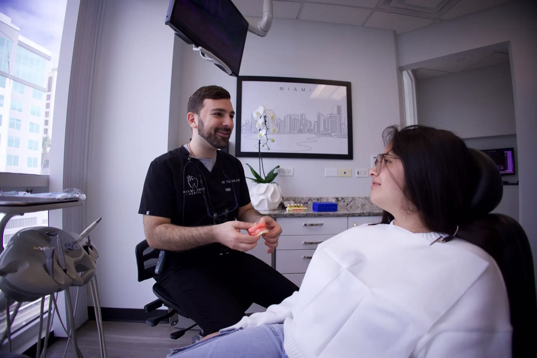 Dr Ali Yazback discutant d'un plan de traitement avec un patient chez Miami Smile Dental