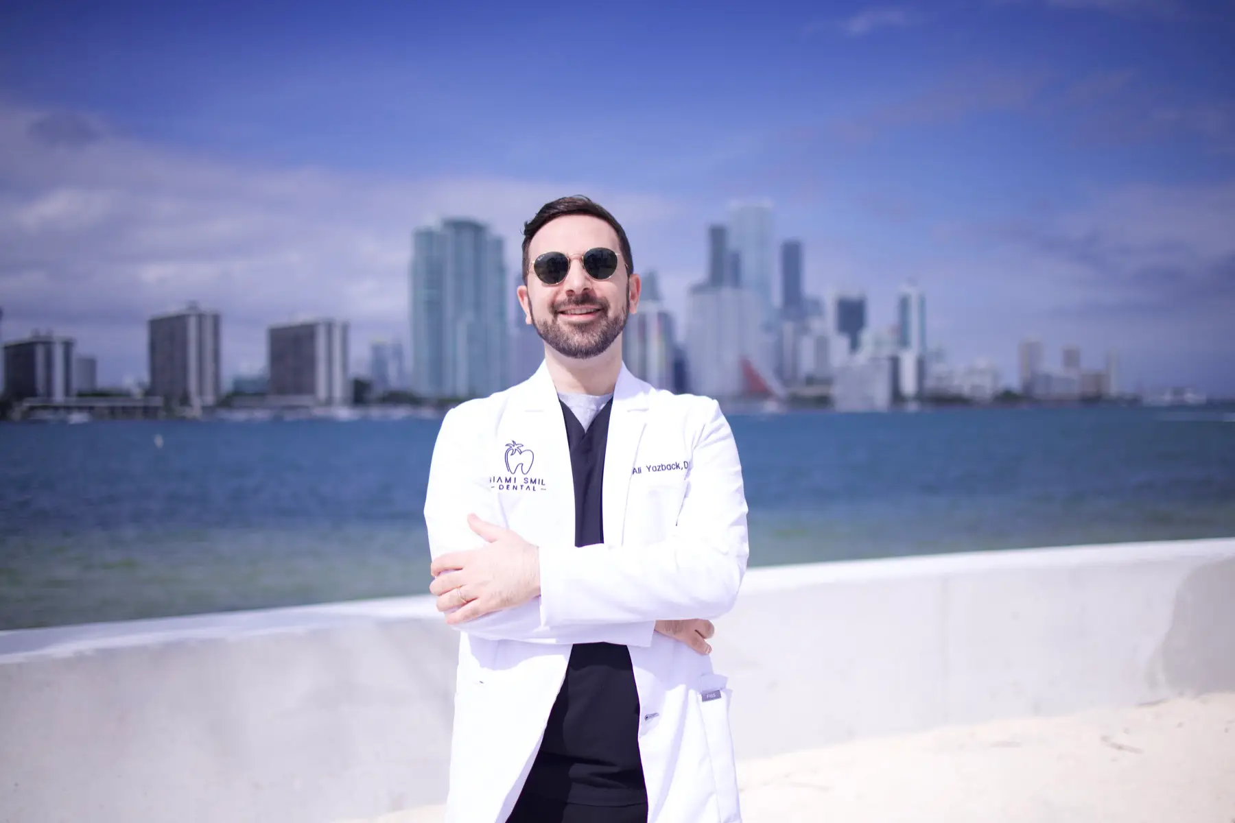 Dr Ali Yazback de Miami Smile Dental, avec la ligne d'horizon de Miami derrière lui